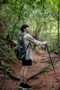 A happy Asian male hiker with a backpack walking along the nature mountain path Royalty Free Stock Photo