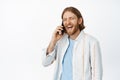 Portrait of handsome happy guy talking on cellphone, laughing and smiling during phone call, standing in casual outfit Royalty Free Stock Photo