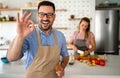 Portrait of handsome happy man cooking at home preparing food in kitchen. Royalty Free Stock Photo