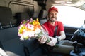 Latin delivery driver giving flowers to a customer Royalty Free Stock Photo