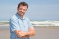 Handsome happy man model wearing blue clothes posing on beach sea background Royalty Free Stock Photo