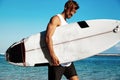 Model surfer wearing casual clothes going with surfboard on blue ocean Royalty Free Stock Photo