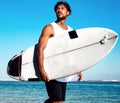 Model surfer wearing casual clothes going with surfboard on blue ocean Royalty Free Stock Photo