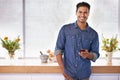 Maybe I should invite some friends over for dinner. Portrait of a handsome holding a mobile phone while standing in the