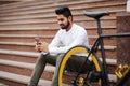 Portrait of handsome indian young man with mobile phone and fixed gear bicycle in the city Royalty Free Stock Photo