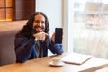 Portrait of handsome intelligence young adult man freelancer in casual style sitting in cafe, pointing finger to empty screen