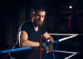 Portrait of handsome kick boxer in the ring at health club