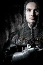 Portrait of handsome knight in suit of armour looking at camera with candles in background Royalty Free Stock Photo