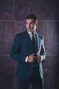 Portrait of handsome macho man touching his black suit Royalty Free Stock Photo