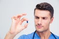 Portrait of a handsome male doctor holding pill Royalty Free Stock Photo