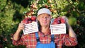 portrait of handsome male farmer holding wooden boxes with red ripe organic apples, smiling. picking apples on the farm Royalty Free Stock Photo