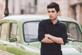 Portrait, handsome, male, model, brunette Mediterranean race Turkish man stands near a retro car of green color posing Royalty Free Stock Photo