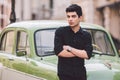 Portrait, handsome, male, model, brunette Mediterranean race Turkish man stands near a retro car of green color posing Royalty Free Stock Photo