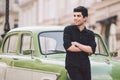 Portrait, handsome, male, model, brunette Mediterranean race Turkish man stands near a retro car of green color posing Royalty Free Stock Photo