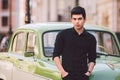 Portrait, handsome, male, model, brunette Mediterranean race Turkish man stands near a retro car of green color posing Royalty Free Stock Photo