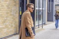 Portrait of a handsome man, businessman, scientist or teacher. He walks along a modern city street with a folder of documents Royalty Free Stock Photo