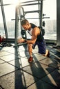 Portrait of a handsome man doing push ups exercise with modern weight equipment in fitness gym. Royalty Free Stock Photo