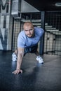 Portrait of a handsome man doing push ups exercise with one hand in fitness gym. dressed in a sports uniform Royalty Free Stock Photo