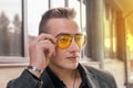 Portrait of a handsome man of European appearance businessman adjusting sunglasses with his hand, close-up on the outdoor of the Royalty Free Stock Photo