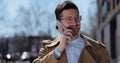 Portrait handsome man in glasses having phone talk on the street. Business man talking on smartphone at street. Outdoor Royalty Free Stock Photo