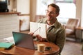 Portrait of handsome man in glasses, working remotely from empty cafe, showing example in his notebook, tutoring, using Royalty Free Stock Photo