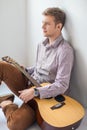 Portrait of handsome man with guitar siting on floor Royalty Free Stock Photo