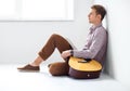 Portrait of handsome man with guitar siting on floor in studio Royalty Free Stock Photo