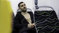 Portrait of handsome man in headphones listening to music in public transport. Media. Young man in empty bus looking