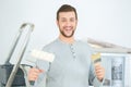 Portrait handsome man holding paint roller in new house Royalty Free Stock Photo