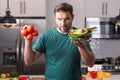 Portrait of handsome man in kitchen. Young man preparing delicious and healthy food in home kitchen. Man with recipe Royalty Free Stock Photo