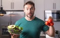 Portrait of handsome man in kitchen. Young man preparing delicious and healthy food in home kitchen. Man with recipe Royalty Free Stock Photo