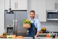 Portrait of handsome man in kitchen. Young man preparing delicious and healthy food in home kitchen. Man with recipe Royalty Free Stock Photo