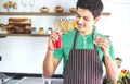 A portrait of handsome man making cold presses fruit juice in a modern kitchen.