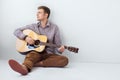 Portrait of handsome man playing guitar siting on floor Royalty Free Stock Photo