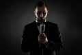 Portrait of handsome man sing on microphone on black background. Royalty Free Stock Photo