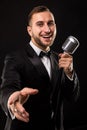 Portrait of handsome man sing on microphone on black background. Royalty Free Stock Photo