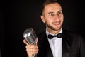 Portrait of handsome man sing on microphone on black background. Royalty Free Stock Photo