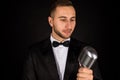 Portrait of handsome man sing on microphone on black background. Royalty Free Stock Photo