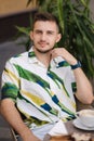 Portrait of handsome man sitting in cafe and drinking cappuccino. Young man Royalty Free Stock Photo