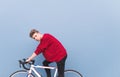 Portrait of handsome man sitting on white bicycle on a background of blue wall and looking at the camera Royalty Free Stock Photo