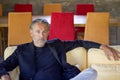 Portrait of handsome man sitting on a yellow sofa in a living room Royalty Free Stock Photo