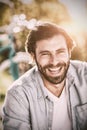 Portrait of handsome man smiling at camera in park on sunny day Royalty Free Stock Photo