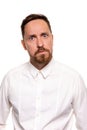 Portrait of handsome man with stubble has indignant expression, frowns face, dressed in white shirt, isolated over white