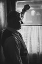 Portrait of handsome man in suit looking out of window in retro