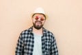 Portrait handsome man wearing summer hat and sunglasses and plaid shirt smiling happy near wall - travel vacations and Royalty Free Stock Photo