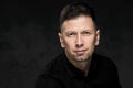 Portrait of a handsome man 40 years old on a dark artistic background close-up. Brunette, with gray hair, black beard Royalty Free Stock Photo