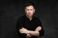 Portrait of a handsome man 40 years old on a dark artistic background close-up. Brunette, with gray hair, black beard Royalty Free Stock Photo