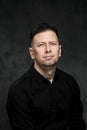 Portrait of a handsome man 40 years old on a dark artistic background close-up. Brunette, with gray hair, black beard Royalty Free Stock Photo