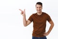 Portrait of handsome masculine young man pointing finger at advertisement, recommend download app, buy subscription or