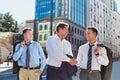 Portrait of handsome mature businessman shaking hands with colleague after meeting against office building Royalty Free Stock Photo